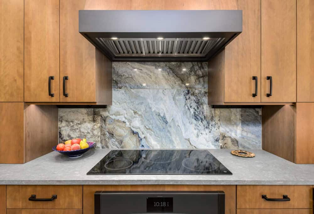 Induction cooktop with a large format tile backsplash that looks like the ocean