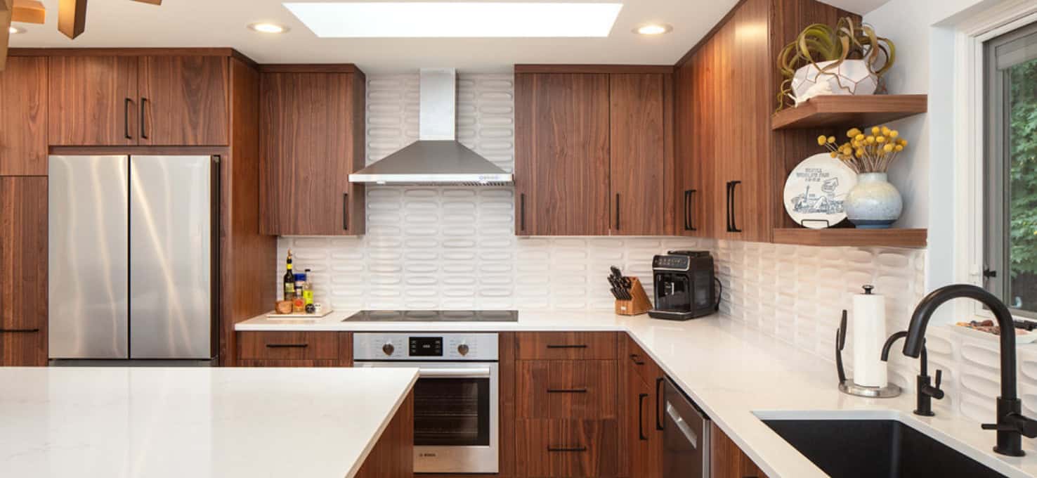 Kitchen with modern oak cabinetry, black pull handles, and stainless steel appliances.