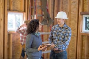 Contractor and project manager talking at a home job site.